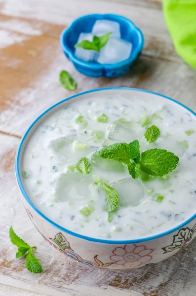 Tzatziki ou cacik, soupe de concombre froid et de yaourt ou salade avec des feuilles de menthe sur fond bois. Concentration sélective — Photo