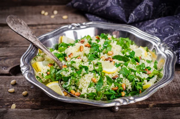 Couscous salad with parsley and pine nuts in vintage bowl on wooden background. Selective focus. Toned image — Zdjęcie stockowe