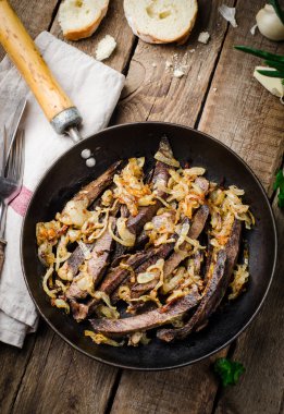 Ahşap arka planda vintage demir tencerede kavrulmuş sığır kalbi. Seçici odaklama