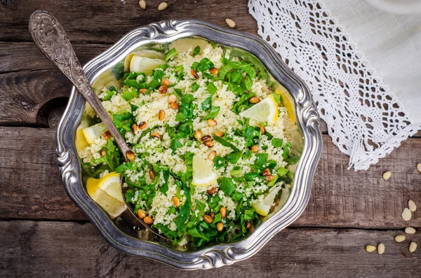 Couscous salad with parsley and pine nuts in vintage bowl on wooden background. Selective focus. Toned image — Zdjęcie stockowe