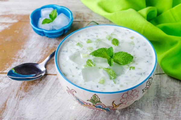 Tzatziki of cacik, koude komkommer en yoghurt soep of salade met mint bladeren op houten achtergrond. Selectieve focus — Stockfoto