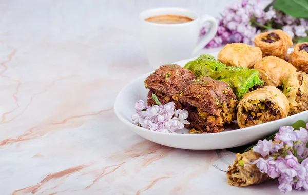 Baklava campuran di piring putih pada latar belakang marmer. Ramadan makanan, masakan arab Turki. Fokus selektif — Stok Foto