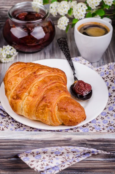 Closeup freshly baked  croissant with strawberry jam and coffee cup  on vintage rustic tray. Breakfast concept. — Stock Photo, Image