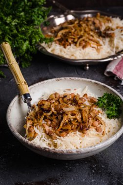 Mujadarra - koyu arka plan üzerinde pirinç, mercimek ve soğan ile arap çanak. Ramazan yemeği. Doğu mutfağı. Seçici odaklama