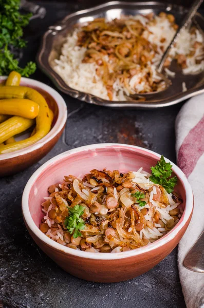 Mujadarra - plato árabe con arroz, lentejas y cebolla sobre fondo oscuro. Comida Ramadán. Cocina oriental. Enfoque selectivo —  Fotos de Stock