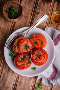 Ahşap arka plan üzerinde beyaz kase pişmiş tavuk dolması domates. Seçici odak