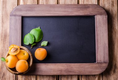 Vintage kayrak tebeşir üzerinde ahşap kase taze olgun kayısı arka plan kurulu. Seçici odak. Arka plan için bazı metin yer ile. Üstten Görünüm