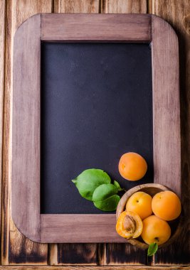 Vintage kayrak tebeşir üzerinde ahşap kase taze olgun kayısı arka plan kurulu. Seçici odak. Arka plan için bazı metin yer ile. Üstten Görünüm