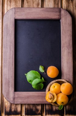 Vintage kayrak tebeşir üzerinde ahşap kase taze olgun kayısı arka plan kurulu. Seçici odak. Arka plan için bazı metin yer ile. Üstten Görünüm