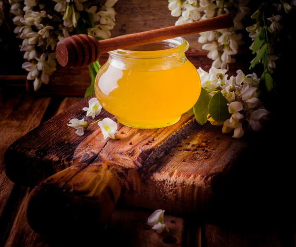 Dolce miele di acacia in vasetti e fiori di acacia su fondo vintage in legno. Immagine tonica. Concentrazione selettiva. Immagine quadrata . — Foto Stock