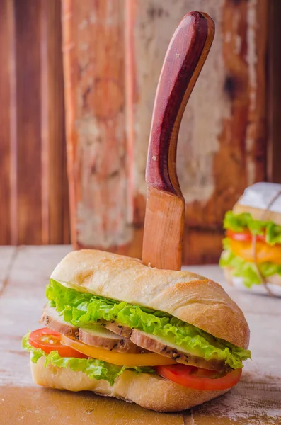Sandwich with roasted chicken, leaves salad and tomatoes on wooden baskgraund. Selective focus — 스톡 사진