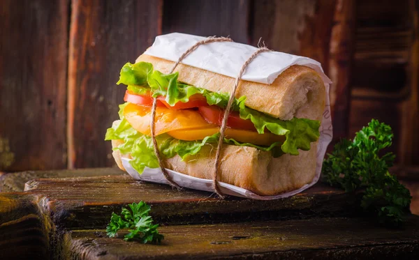 Sandwich avec salade de feuilles et tomates sur bassingraund en bois. Concentration sélective — Photo