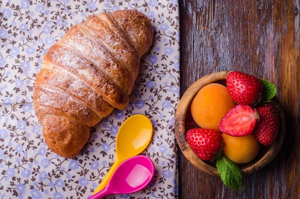 Croissant with strawberry and apricots on over white linen tablecloth.. Breakfast concept. Selective focus. Top view — Stock Photo, Image