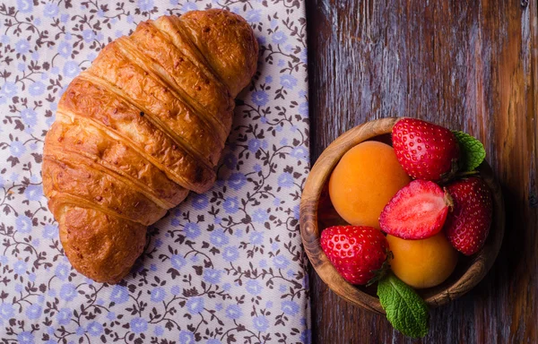 Croissant with strawberry and apricots on over white linen tablecloth.. Breakfast concept. Selective focus. Top view — Stock Photo, Image