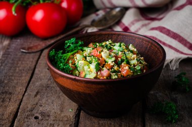 Taze tabbouleh, bir Orta Doğu salatası, ahşap arka plan üzerinde kil kase. Seçici odak. Tonlu görüntü