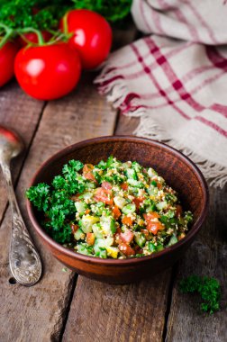 Taze tabbouleh, bir Orta Doğu salatası, ahşap arka plan üzerinde kil kase. Seçici odak. Tonlu görüntü