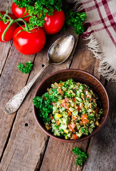 Taze tabbouleh, bir Orta Doğu salatası, ahşap arka plan üzerinde kil kase. Seçici odak. Tonlu görüntü