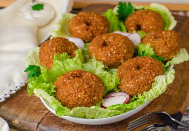 Ahşap arka plan üzerinde plaka üzerinde marul ile Falafel topları. Seçici odaklama