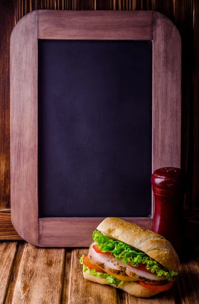 Hamburger sandwich frais fait maison sur fond de panneau de craie d'ardoise vintage. Concentration sélective. Contexte avec un certain endroit pour le texte — Photo