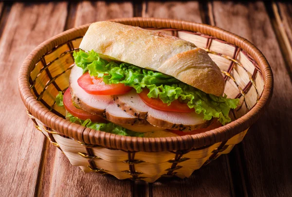 나무 배경에 바구니에 신선한 토마토와 닭 가슴살을 수제 샌드위치. 선택적 초점. 피크닉 컨셉 — 스톡 사진