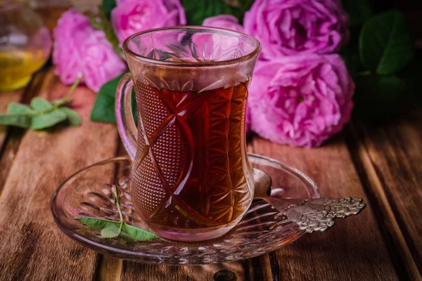 Turecký čaj ve sklenici na dřevěné pozadí s růžemi. Ramadánových jídel. Selektivní zaměření — Stock fotografie