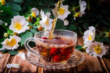 Ahşap bir tahtada köpek gülistanlı sağlıklı çay. Seçici odaklama