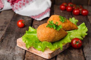 Tavuk pirzola kırıntıları - tavuk Kiev ahşap tahta ve ahşap arka plan içinde. Ukraynalı mutfağı. Seçici odak