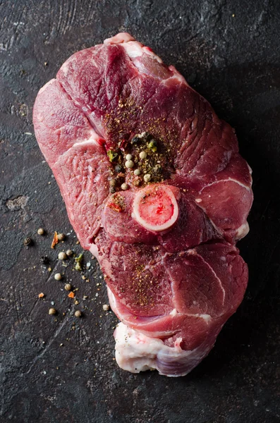 Raw Mutton meat with east spice on dark background.