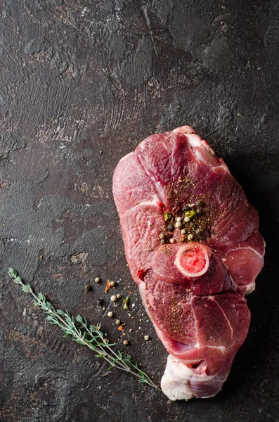 Viande de mouton crue avec épice orientale sur fond sombre . — Photo