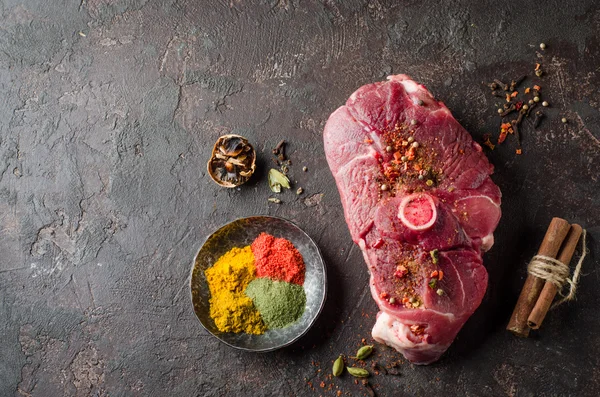 Rohes Hammelfleisch mit Ost-Gewürz auf dunklem Hintergrund. — Stockfoto