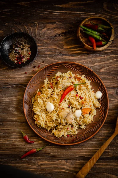 Pollo Biryani. Pilaf de arroz con pollo, ajo y chile en plato de barro sobre fondo de madera. Comida Ramadán. Cocina india. Enfoque selectivo. Imagen tonificada —  Fotos de Stock