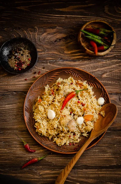 Csirke Biryani. Rizspilaf csirkével, fokhagymával és chili paprikával agyagtányéron, fa alapon. Ramadán kaja. Indiai konyha. Szelektív fókusz. Tonozott kép — Stock Fotó