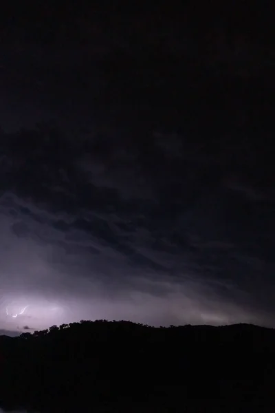 Starke Blitze Und Hinter Großen Aufragenden Gewitterwolken — Stockfoto