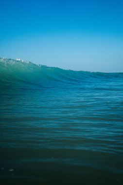 Kırılan dalgalar ve sprey, hareket eden suyun yüzeyine yansıyan beyaz su ve ışık.