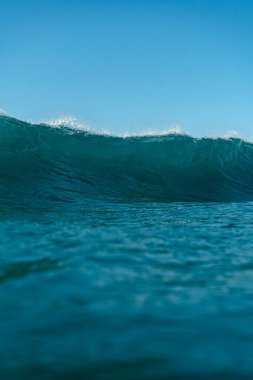 Kırılan dalgalar ve sprey, hareket eden suyun yüzeyine yansıyan beyaz su ve ışık.