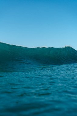 Kırılan dalgalar ve sprey, hareket eden suyun yüzeyine yansıyan beyaz su ve ışık.