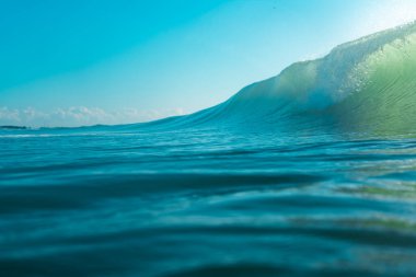 Kırılan dalgalar ve sprey, hareket eden suyun yüzeyine yansıyan beyaz su ve ışık.