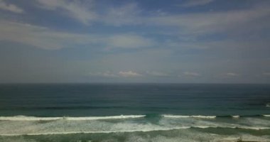 Kuzey İspanya 'nın kayalık kıyı şeridinin insansız hava aracı görüntüleri. Gelen dalgalar, bulutlar ve güneş ışığıyla dolu bir sahil.