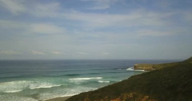 Kuzey İspanya 'nın kayalık kıyı şeridinin insansız hava aracı görüntüleri. Gelen dalgalar, bulutlar ve güneş ışığıyla dolu bir sahil.
