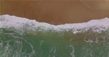 Kırılan dalgalar ve spreyle yaklaşan kıyı bölgesinin havadan görüntüsü