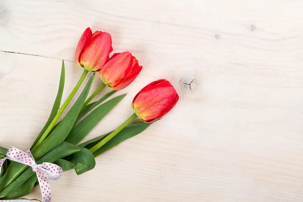 Tulipani rossi su uno sfondo di legno. Spazio per il testo. Vista dall'alto — Foto Stock