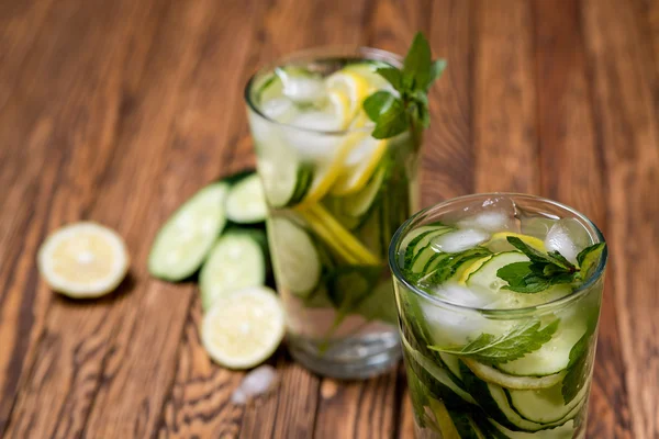 Water with lemon, mint and cucumber on wooden background. Water Detox. — Stock Photo, Image