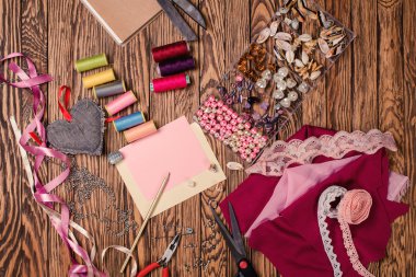 Ahşap arka plan, malzemeler ve araçlar üzerine yerleştirilmiş iğne işi için ayarlayın. Üstten Görünüm.