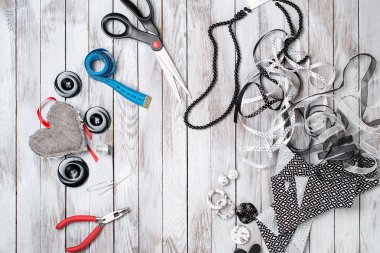 Makas, düğmeler, aksesuar beyaz ahşap zemin üzerinde. El yapımı işyeri. Üstten Görünüm.