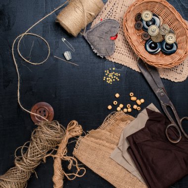 İğne işi için ayarla: siyah arka plan üzerine bir ip ile keten kumaş, makas. Üstten Görünüm.