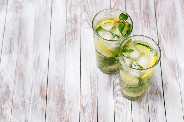 Water with lemon, mint and cucumber on wooden light background. Water Detox. — Stock Photo, Image