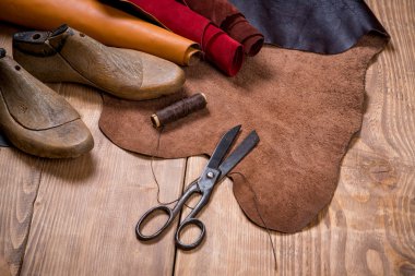 Ahşap arka plan üzerinde deri el sanatları araçlar kümesi. İş yeri için Ayakkabıcılık.
