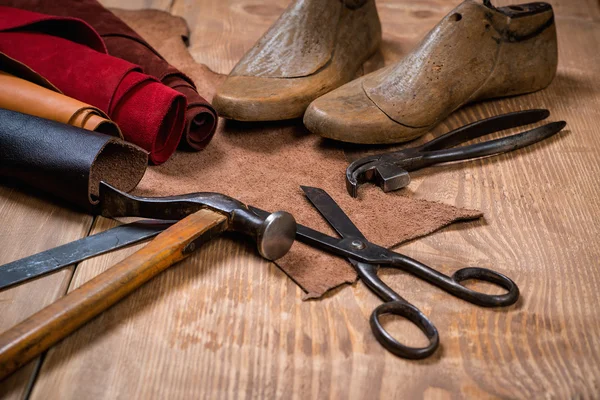 Conjunto de ferramentas de artesanato de couro em fundo de madeira. Local de trabalho para sapateiro . — Fotografia de Stock