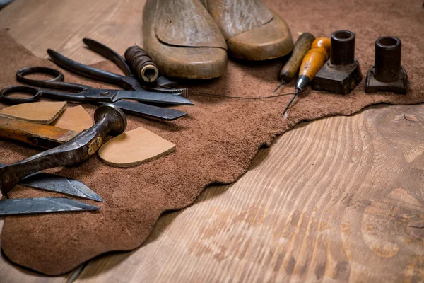 Zestaw narzędzi rzemieślniczych skóry na tle drewnianych. Miejsca pracy dla szewca. — Zdjęcie stockowe