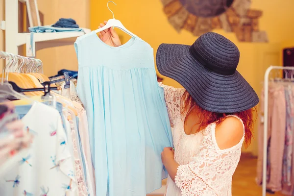 Mujer joven en negro sombrero de compras en la tienda de mujeres. Hora de comprar. Venta de verano . — Foto de Stock